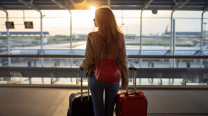 A traveling female in airport collecting a baggage trolley and waiting for flight. Generative AI
