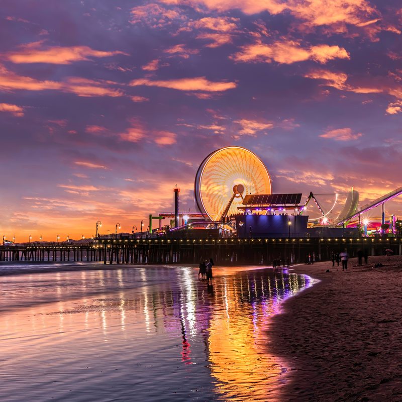 Píer de Santa Monica com a roda-gigante iluminada ao pôr do sol